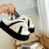 UGG sheepskin and fur slippers in black and white. Thick-soled platform slippers with cross-hairs. Available in sizes 36-40